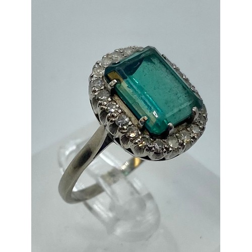 141 - An 18 ct white gold Emerald and Diamond dress ring central step cut Emerald, 13 x 9 mm approx with a... 