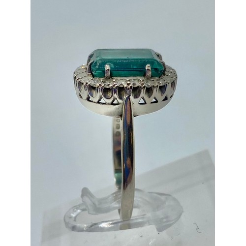 141 - An 18 ct white gold Emerald and Diamond dress ring central step cut Emerald, 13 x 9 mm approx with a... 