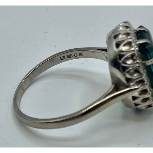 141 - An 18 ct white gold Emerald and Diamond dress ring central step cut Emerald, 13 x 9 mm approx with a... 