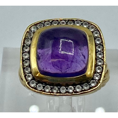 154 - A gilt silver and amethyst ladies dress ring set with free cut cabochon amethyst and a surround of s... 