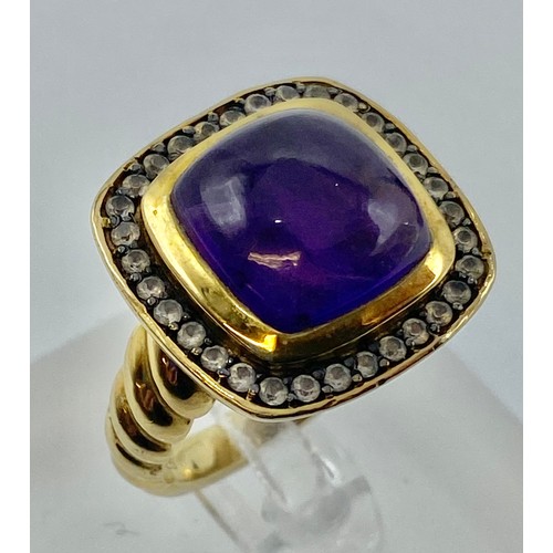 154 - A gilt silver and amethyst ladies dress ring set with free cut cabochon amethyst and a surround of s... 