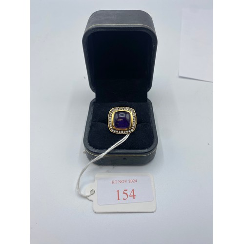 154 - A gilt silver and amethyst ladies dress ring set with free cut cabochon amethyst and a surround of s... 