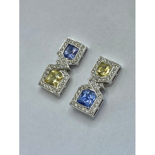 148 - A pair of 18ct white gold sapphire,  fancy yellow sapphire and diamond drop earrings/ Each set with ... 