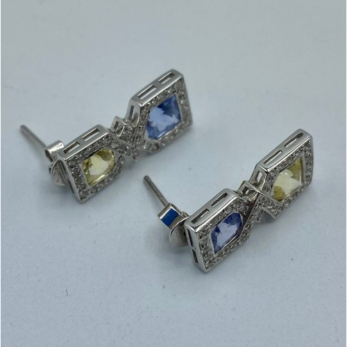 148 - A pair of 18ct white gold sapphire,  fancy yellow sapphire and diamond drop earrings/ Each set with ... 