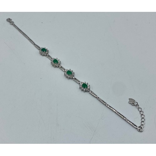 153 - A silver and emerald bracelet set with four oval free cut emeralds/ 7.7g. 18cm