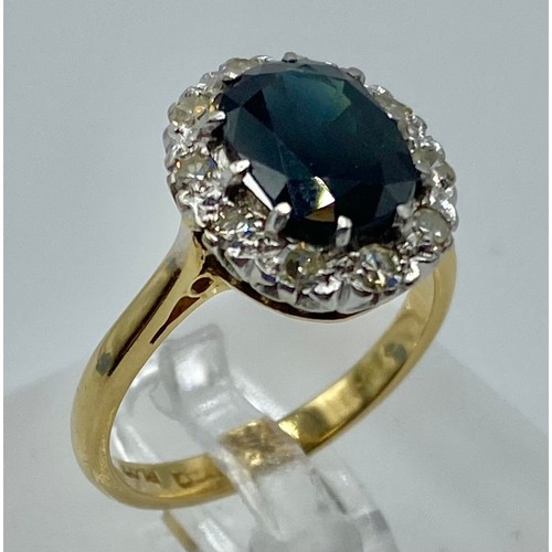 173 - An 18ct gold and platinum sapphire and diamond dress ring. Oval mixed cut sapphire with feint colour... 