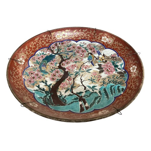 215 - A large Japanese charger, 37.5cm diameter, decorated trees and birds, and verso rim with foliage, as... 