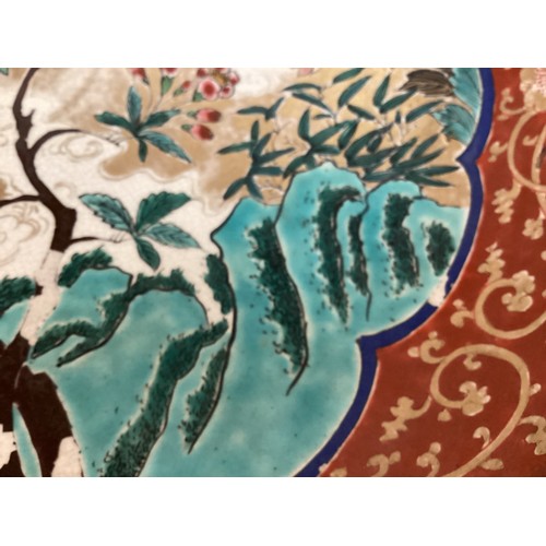 215 - A large Japanese charger, 37.5cm diameter, decorated trees and birds, and verso rim with foliage, as... 