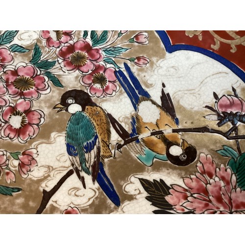 215 - A large Japanese charger, 37.5cm diameter, decorated trees and birds, and verso rim with foliage, as... 