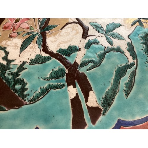 215 - A large Japanese charger, 37.5cm diameter, decorated trees and birds, and verso rim with foliage, as... 