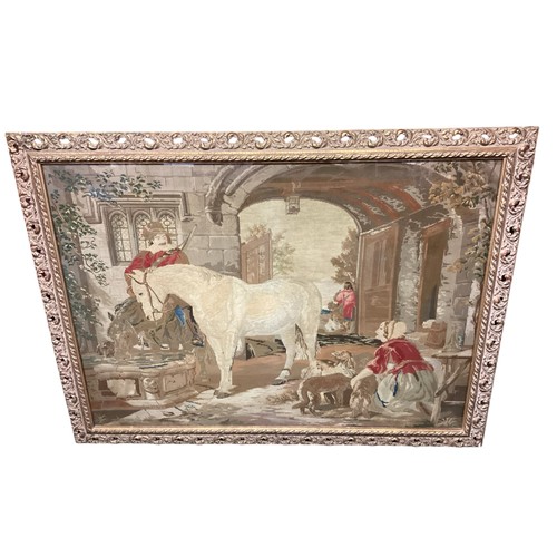 432 - Large framed and glazed tapestry of period courtyard scene of a cavalier man and horse  85cm x 118cm