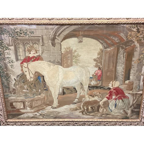 432 - Large framed and glazed tapestry of period courtyard scene of a cavalier man and horse  85cm x 118cm