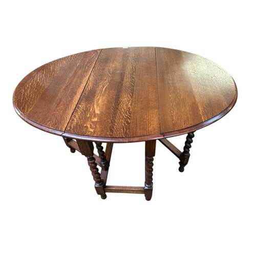 530 - A small honey coloured oak oval gateleg table, with barley twist supports, 90cm Wide closed