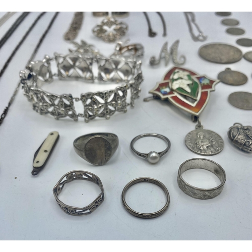 29 - A collection of sterling silver and white metal items to include an enamel brooch, thimbles pendants... 