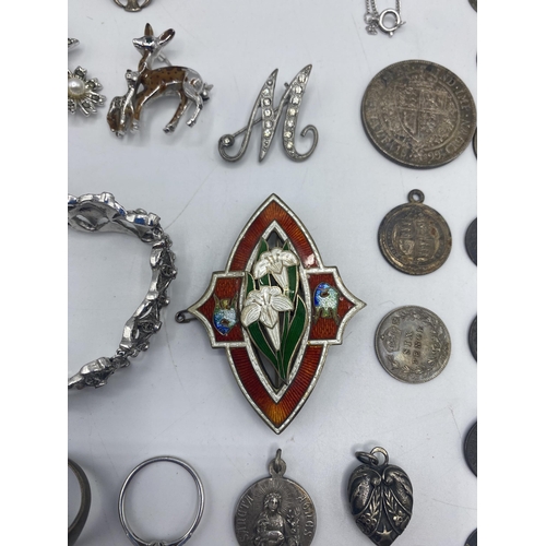 29 - A collection of sterling silver and white metal items to include an enamel brooch, thimbles pendants... 