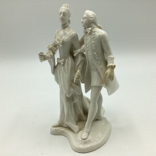 242 - A Nymphenburg, Dresden white porcelain figure group of a man and woman in 19th century dress. Some r... 