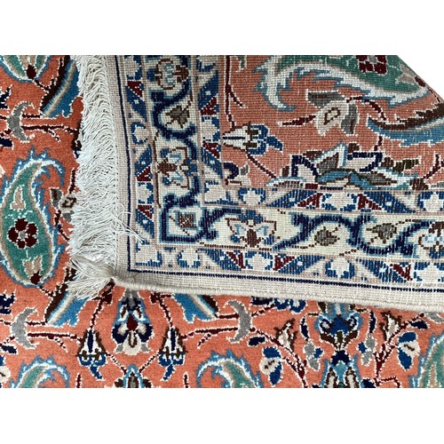 351 - A wool rug with repeat paisley pattern and pattern borders, with salmon orange ground and patterns o... 