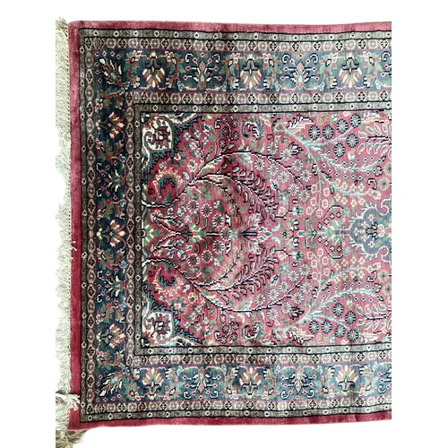 352 - A Kashmir silk rug with pink background and blue and pink border and floral pattern, 94cm x 156cm. G... 