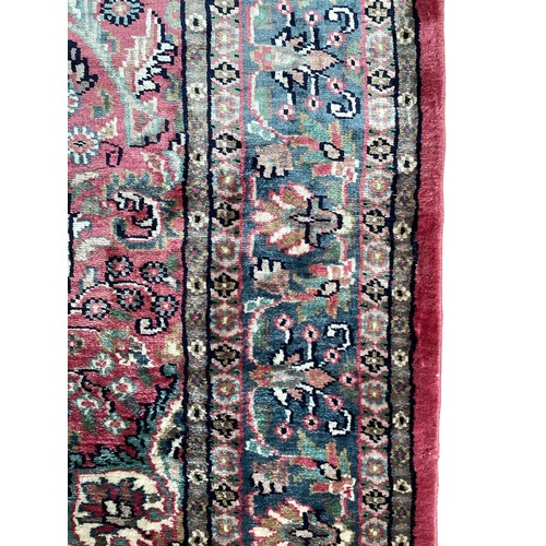 352 - A Kashmir silk rug with pink background and blue and pink border and floral pattern, 94cm x 156cm. G... 