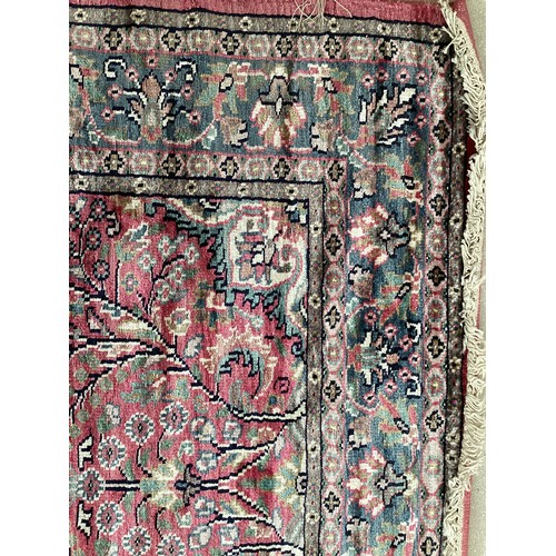 352 - A Kashmir silk rug with pink background and blue and pink border and floral pattern, 94cm x 156cm. G... 