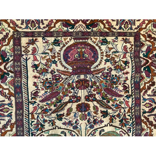 360 - Persian rug, central pattern of flower vases and weeping women and ornate borders with birds. Colour... 