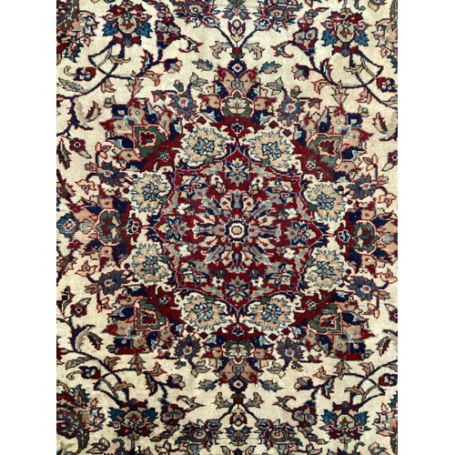 361 - Large Persian wool rug with central ornate pattern and borders. Main colours are cream background wi... 