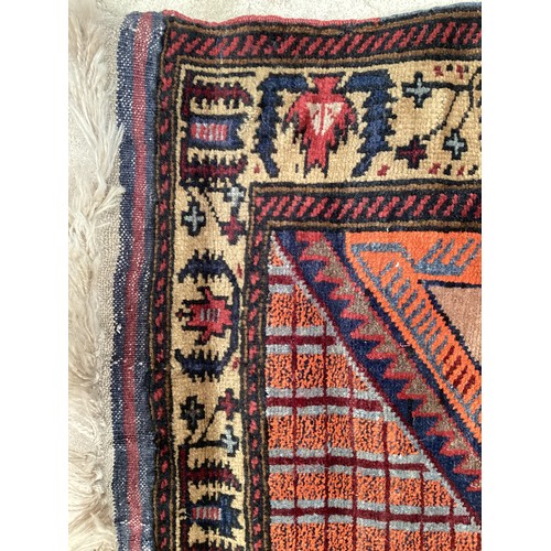 366 - Wool handmade rug with central pattern depicting a temple and border. Main colours are brown, orange... 