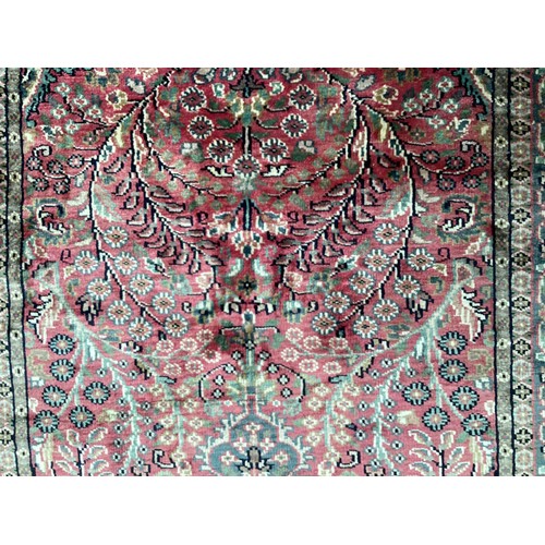 352 - A Kashmir silk rug with pink background and blue and pink border and floral pattern, 94cm x 156cm. G... 