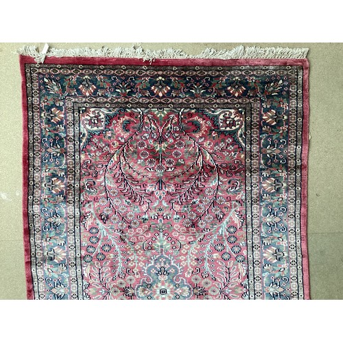 352 - A Kashmir silk rug with pink background and blue and pink border and floral pattern, 94cm x 156cm. G... 