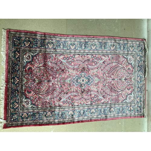 352 - A Kashmir silk rug with pink background and blue and pink border and floral pattern, 94cm x 156cm. G... 