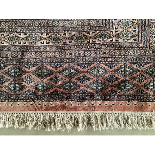 359 - Large Persian style rug with geometric central pattern and borders, main colours are pink and blues,... 