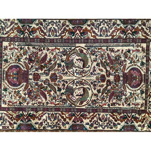 360 - Persian rug, central pattern of flower vases and weeping women and ornate borders with birds. Colour... 