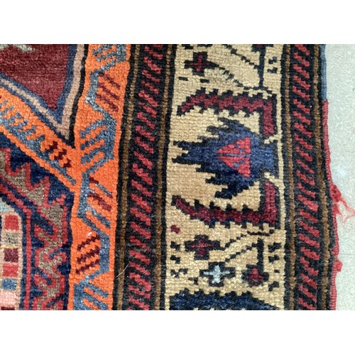 366 - Wool handmade rug with central pattern depicting a temple and border. Main colours are brown, orange... 