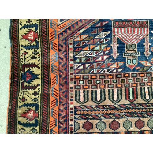 366 - Wool handmade rug with central pattern depicting a temple and border. Main colours are brown, orange... 