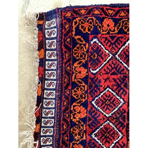 368 - Oriental wool handmade rug with embossed central design and a border. Main colours are red, blue and... 