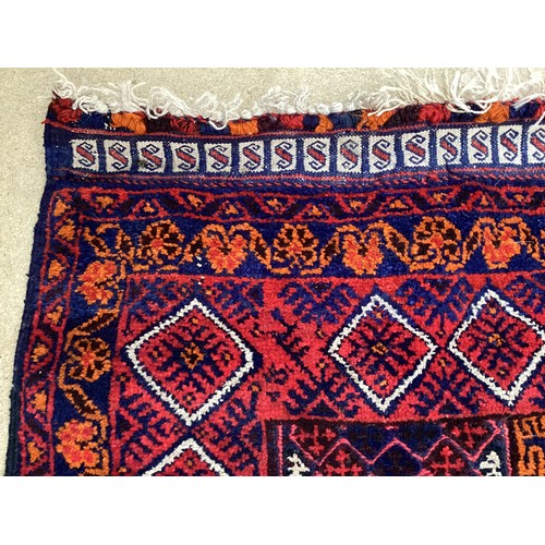 368 - Oriental wool handmade rug with embossed central design and a border. Main colours are red, blue and... 