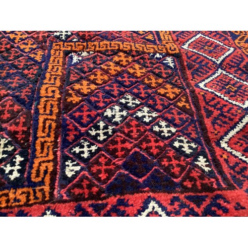 368 - Oriental wool handmade rug with embossed central design and a border. Main colours are red, blue and... 