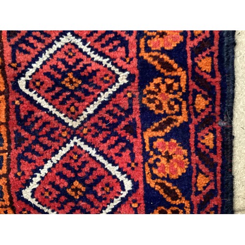 368 - Oriental wool handmade rug with embossed central design and a border. Main colours are red, blue and... 