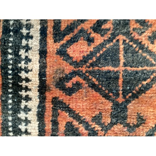 369 - Wool handmade rug with central pattern and border. Main colours are orange and brown. Condition- few... 