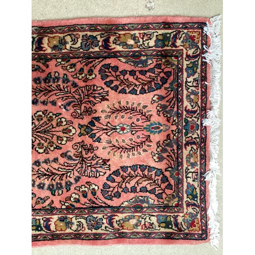 370 - Oriental wool rug with central pattern and border, pink background with blues, cream and yellow. Gen... 