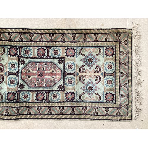 370 - Oriental wool rug with central pattern and border, pink background with blues, cream and yellow. Gen... 