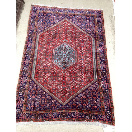 374 - A Persian style red ground rug, see photos for details.  Condition good.  116 cm x 170 cm