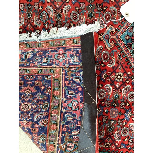 374 - A Persian style red ground rug, see photos for details.  Condition good.  116 cm x 170 cm