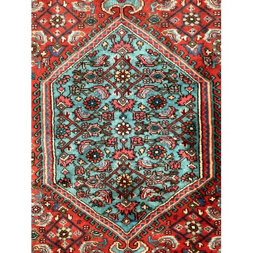 374 - A Persian style red ground rug, see photos for details.  Condition good.  116 cm x 170 cm