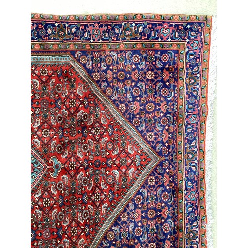 374 - A Persian style red ground rug, see photos for details.  Condition good.  116 cm x 170 cm