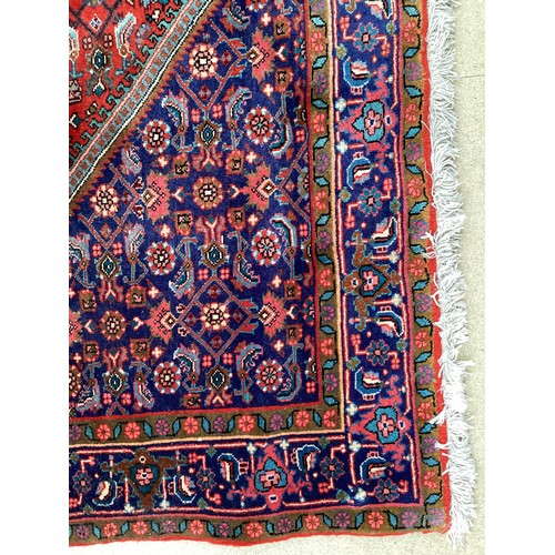 374 - A Persian style red ground rug, see photos for details.  Condition good.  116 cm x 170 cm