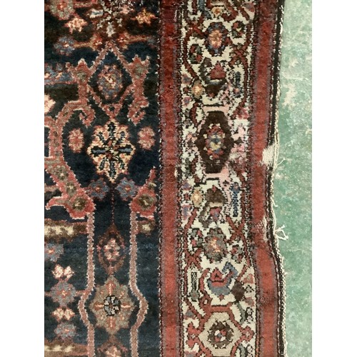 385 - A Persian style rug with all over geometric pattern of browns, blues and red colour, and cream groun... 