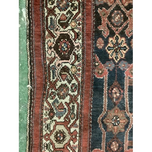 385 - A Persian style rug with all over geometric pattern of browns, blues and red colour, and cream groun... 