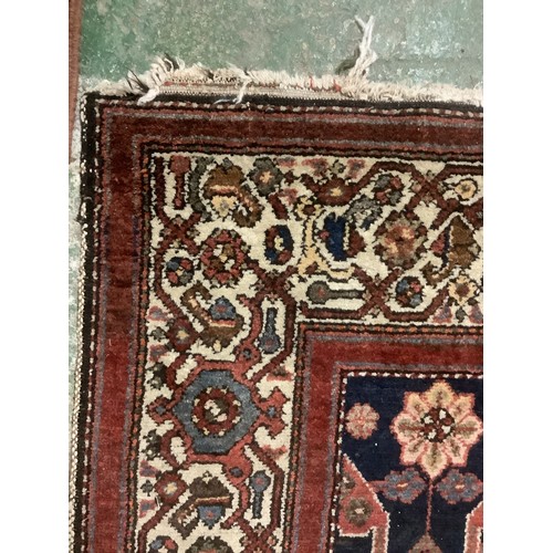 385 - A Persian style rug with all over geometric pattern of browns, blues and red colour, and cream groun... 