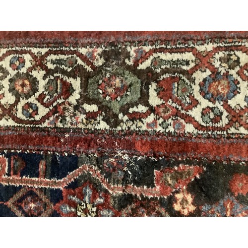 385 - A Persian style rug with all over geometric pattern of browns, blues and red colour, and cream groun... 